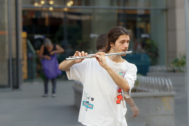 Boy playing flute in a public place